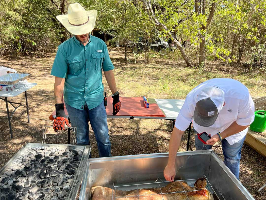 Ricardo checks the pig roast once again.