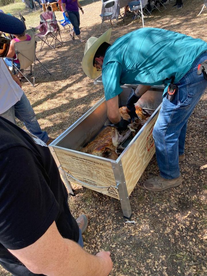 Cutting meat off the bone for the crowd.